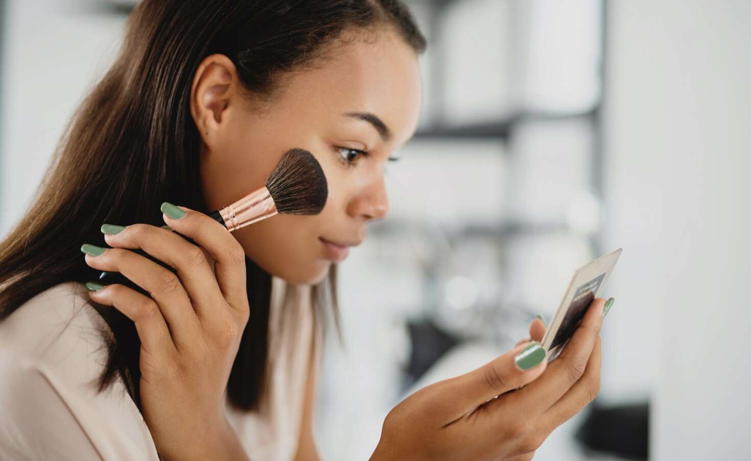 Beautiful young woman applying make up.