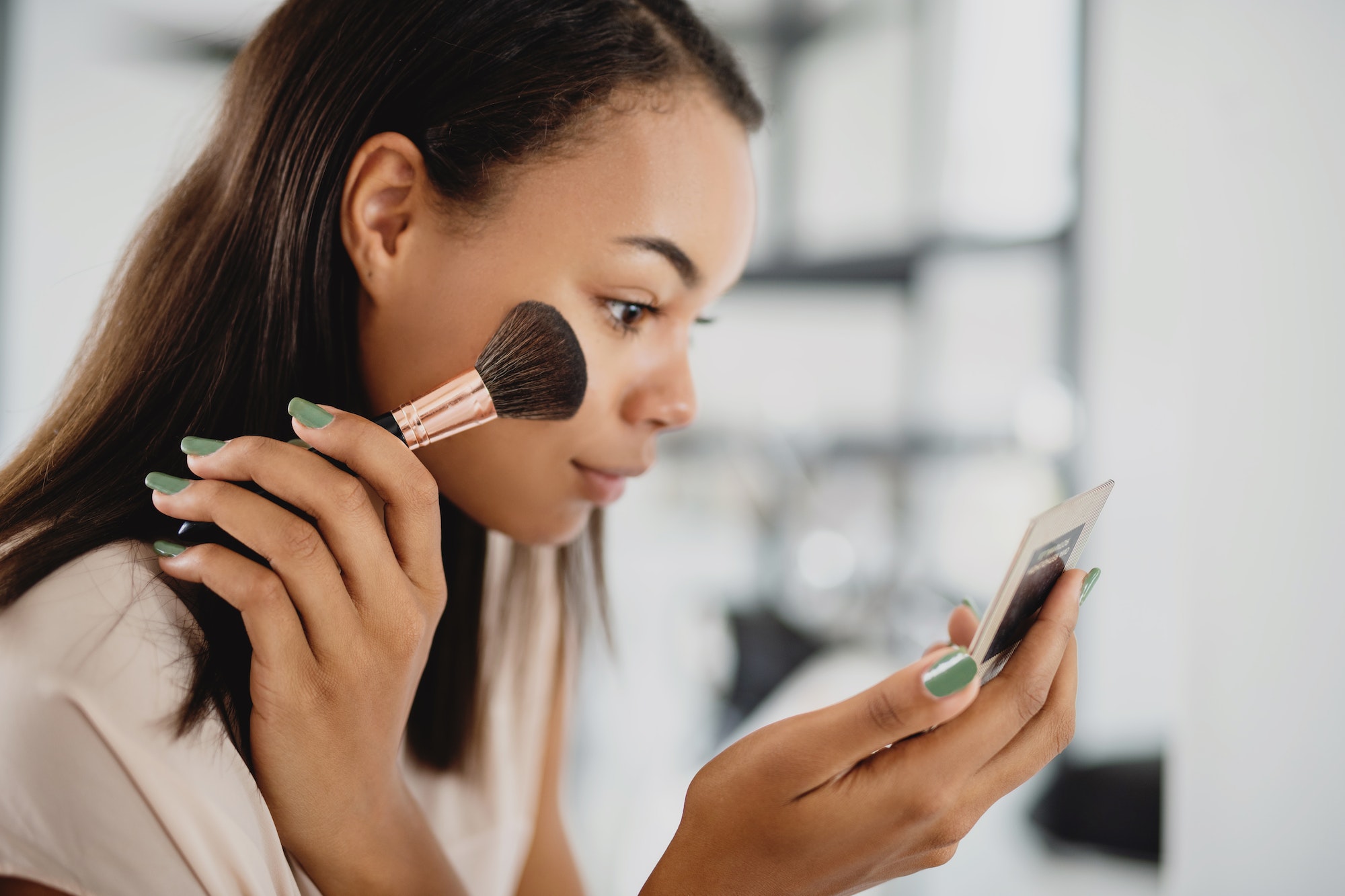 Beautiful young woman applying make up.